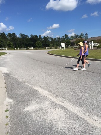 Makayla and Joanne using their canes to cross through a roundabout